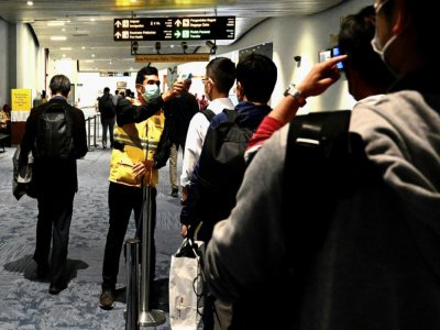 La température de voyageurs débarquant à l'aéroport de Jakarta est contrôlée, le 23 février 2020 - GOH CHAI HIN [AFP]