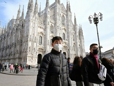 Des touristes portant des masques, à Milan, le 23 février 2020 - ANDREAS SOLARO [AFP]