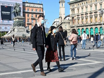 Des passants portant des masques, sur la Piazza del Duomo, le 24 février 2020 à Milan - Andreas SOLARO [AFP]