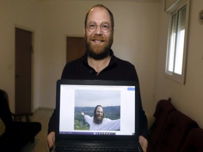 L'Israélien Avi Tfilinksi dans son appartement près de Jérusalem le 10 février 2020. Cet ancien juif ultra-ortodoxe montre une photo de lui de l'époque où il était pratiquant - MENAHEM KAHANA [AFP]