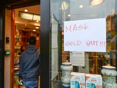 Une pharmacie indique sur sa devanture être en rupture de stocks pour les masques de protection, dans le quartier chinois de Milan, le 25 février 2020 - Miguel MEDINA [AFP]