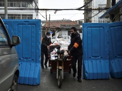 Des volontaires livrent des provisions à des personnes en quarantaine chez elles, le 26 février 2020 à Wuhan; dans le centre de la Chine - STR [AFP/Archives]