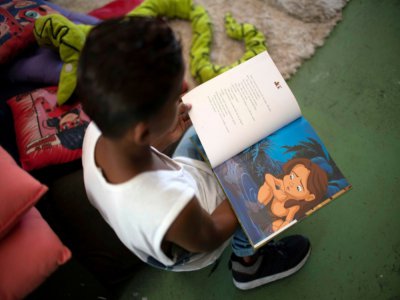 Un jeune garçon lit, à la bibliotèque "Mundo da Lua"à Rio de Janeiro le 10 mars 2020 - MAURO PIMENTEL [AFP]