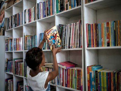 Un jeune garçon replace un livre sur une étagère de la bibliothèque "Mundo da Lua" à Rio de Janeiro, le 10 mars 2020 - MAURO PIMENTEL [AFP]