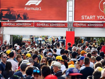 Des spectateurs attendent devant les grilles du circuit de Melbourne, le 13 mars 2020 - William WEST [AFP]