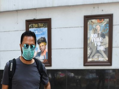 Un homme portant un masque de protection passe devant un cinéma fermé, le 13 mars 2020 à New Delhi, en Inde - Prakash SINGH [AFP]