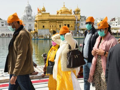 Des fidèles portant des masques de protection viennent prier au Temple d'Or d'Amritsar, édifice sacré des Sikhs, le 13 mars 2020 en Inde - Narinder NANU [AFP]