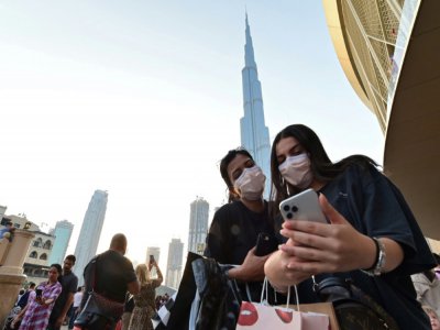 Des femmes avec des masques de protection devant la tour Burj Khalifa, à Dubaï, aux Emirats, le 8 mars 2020 - GIUSEPPE CACACE [AFP]