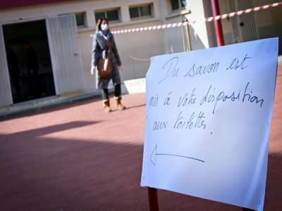 Une femme dans un bureau de vote de Marseille au 1er tour des municipales, le 15 mars 2020 - GERARD JULIEN [AFP]
