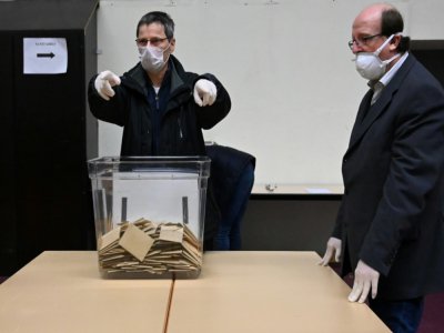 Des personnels portant des masques de protection et des gants dans un bureau de vote à Strasbourg, le 15 mars 2020 - Frederick Florin [AFP]