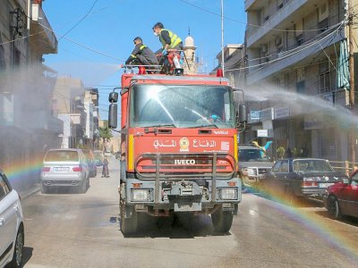 Des membres de la défense civile diffusent du désinfectant dans les rues de Baalbeck, le 16 mars 2020 - - [AFP]
