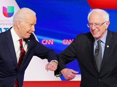 Joe Biden et Bernie Sanders, candidats à la primaire démocrate, se saluent du coude avant le début du débat télévisé sur CNN, le 16 mars 2020 à Washington - Mandel NGAN [AFP]