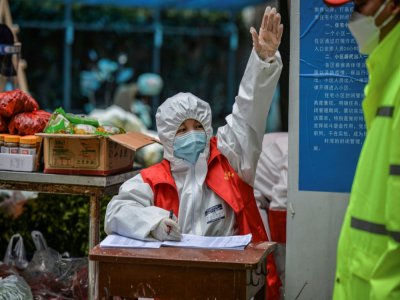 Un bénévole lors d'une distribution alimentaire à Wuhan, le 16 mars 2020 - STR [AFP/Archives]