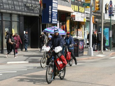 Des livreurs de nourriture se mettent en route dans le quartier de Brooklyn, à New York, le 16 mars 2020 - Angela Weiss [AFP]