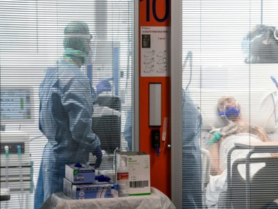 Des membres du personnel médical en combinaison de protection prodiguent des soins à un patient atteint par le nouveau coronavirus dans une unité spéciale de l'hôpital de Brescia, le 17 mars 2020 en Italie - Piero CRUCIATTI [AFP]