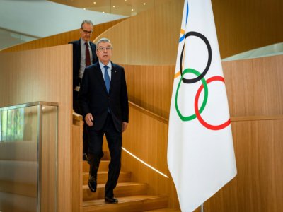 Thomas Bach, le président du Comité intrernatikonal olympique, suivi par le porte-parole de l'instance Mark Adams le 3 mars 2020 au siège de l'instance à Lausanne - Fabrice COFFRINI [AFP/Archives]