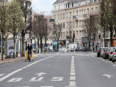 Rue de Bernières à Caen, un livreur à vélo poursuit son activité.