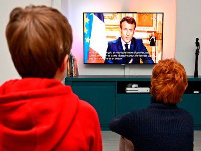 Des enfants devant l'allocution télévisée du président Emmanuel Macron le 16 mars 2020, à Rennes - Damien Meyer [AFP]
