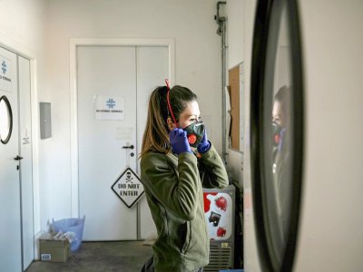 Une soigneuse du zoo  "Zoom Torino" ajuste son masque de protection contre le coronavirus, le 18 mars 2020 à Cumiana, près de  Turin (Italie) - MARCO BERTORELLO [AFP]