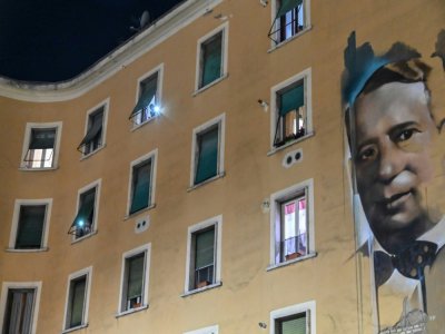 Des habitants de Rome allument la torche de leur téléphone aux fenêtres le soir, de façon concertée, dans le quartier Garbatella à Rome, le 15 mars 2020 - Andreas SOLARO [AFP/Archives]