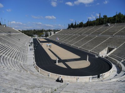 Cérémonie de transmission de la flamme olympique au Japon par la Grèce devant les tribunes vides du stade panathénaïque le 19 mars 2020 à Athènes - ARIS MESSINIS [POOL/AFP]