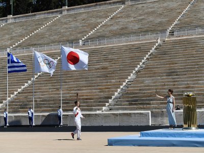 Un athlète assure le dernier relais de la flamme olympique avant la cérémonie de sa remise solennelle au Japon, le 19 mars 2020 à Athènes . - ARIS MESSINIS [AFP]