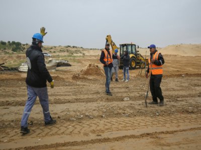 Des ouvriers palestiniens et des membres du ministère de la Santé de Gaza sur un chantier de construction d'un hopital en prévision de l'arrivée du nouveau coronavirus dans l'enclave, le 17 mars 2020 - SAID KHATIB [AFP]