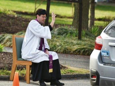 Le père Scott Holmer donne l'absolution après une confession à Bowie (Maryland) le 20 mars 2020 - MANDEL NGAN [AFP]