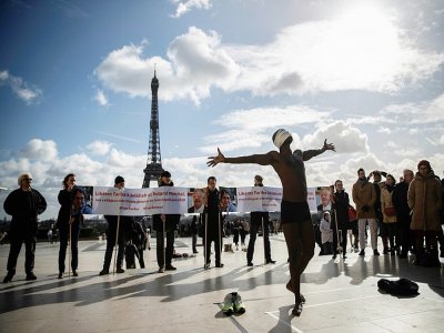 Performance artistique du Sénégalais Alioune Diagne à l'occasion d'une manifestation de soutien aux deux chercheurs détenus en Iran, le 11 février 2020 à Paris - Thomas SAMSON [AFP/Archives]