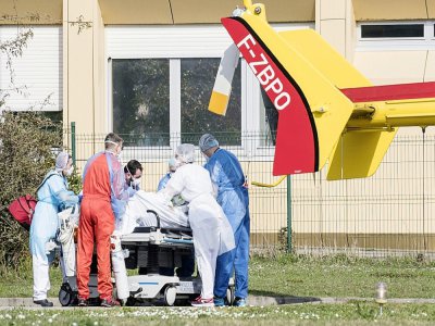 Du personnel médical s'occupe d'un malade du Covid-19 pour le transporter dans un hélicoptère depuis l'hôpital Emile Muller à Mulhouse, le 20 mars 2020 - SEBASTIEN BOZON [AFP]