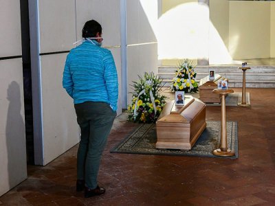 Une femme devant le cercueil d'un proche dans le cimetière de Zogno, près de Bergamo, (nord de l'Italie), le 21 mars 2020 - Piero Cruciatti [AFP]