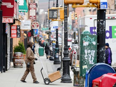 Un livreur de colis dans ue rue désertée de Brooklyn à New York le 20 mars 2020 - Angela Weiss [AFP]