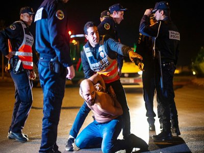 La police marocaine arrête un homme refusant d'obtempérer aux mesures de confinement, le 21 mars 2020 à Casablanca - RIZKOU ABDELMJID [AFP]