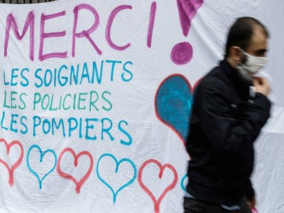 Une affiche géante pour remercier les soignants, policiers et pompiers, dans les rues de Paris le 21 mars 2020 - JOEL SAGET [AFP]