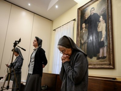 Des religieuses prient lors d'une messe retransmise en streaming à la chapelle Saint Jean Bosco à Saluces, dans le Piemont, nord de l'Italie, le 22 mars 2020 - MARCO BERTORELLO [AFP]