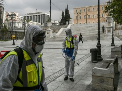 Des agents de la municipalité désinfectent la place Syntagma à Athènes, le 23 mars 2020 - Aris MESSINIS [AFP]
