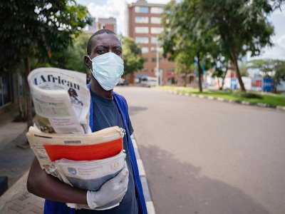 Un vendeur de journaux dans les rues de Kigali, le 22 mars 2020 - Simon Wohlfahrt [AFP]