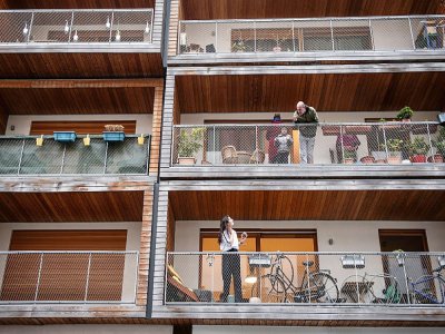 Discussions entre voisins confinés, depuis leur balcon, à Paris le 20 mars 2020 - Martin BUREAU [AFP]