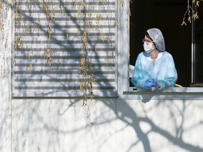 Un membre du personnel soignant se repose quelques minutes à la fenêtre de l'hôpital Emile Muller à Mulhouse, le 24 mars 2020 - SEBASTIEN BOZON [AFP]