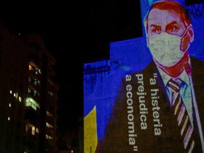 Une image du président brésilien Jair Bolsonaro, accompagné de la phrase "l'hystérie fait du mal à l'économie", est projetée sur le mur d'un immeuble à Sao Paulo le 21 mars 2020, dans le cadre de plusieurs actions critiquant la position du chef de l' - Miguel SCHINCARIOL [AFP/Archives]