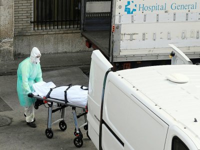 Un corps est transporté hors de l'hôpital Gregorio Maranon, à Madrid, le 25 mars 2020 - OSCAR DEL POZO [AFP]