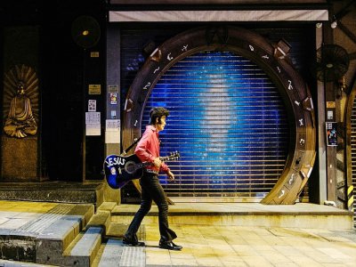 A Hong Kong, le chanteur Kwok Lam-sang, surnommé Melvis pour ses imitations d'Elvis Presley, seul dans le quartier des bars inanimé de Lan Kwai Fong, à Hong Kong - Anthony WALLACE [AFP]