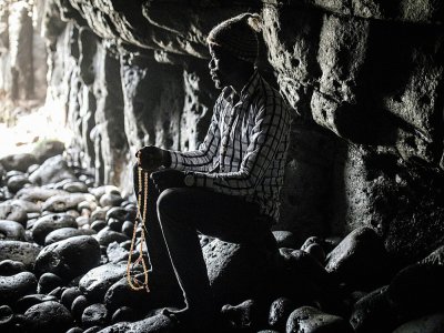 A Dakar, un homme de la communauté Layenne prie dans la Grotte sacrée d'Almadies où a lieu un pèlerinage annuel, annulé pendant l'épidémie du nouveau coronavirus le 23 mars 2020 à Dakar, au Sénégal - John WESSELS [AFP]