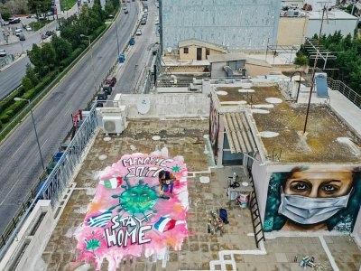A Athènes, des graffitis du tagueur S.F., 16 ans, pour faire passer le message: "Restez à la maison", le 23 mars 2020 - Aris Messinis [AFP]