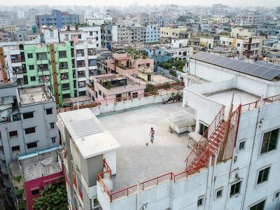 A Dacca, un enfant joue seul au ballon sur le toit d'un immeuble, le 23 mars 2020 au Bangladesh - Munir UZ ZAMAN [AFP]