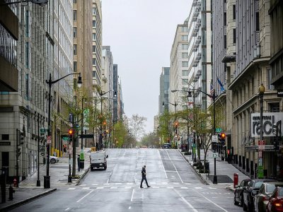 Un piéton solitaire traverse la 14e rue à Washington, le 25 mars 2020 - Eric BARADAT [AFP/Archives]