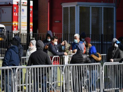 Des New-Yorkais attendent pour se soumettre au test de dépistage du coronavirus à l'hôpital d'Elmhurst, le 26 mars 2020 - Angela Weiss [AFP]