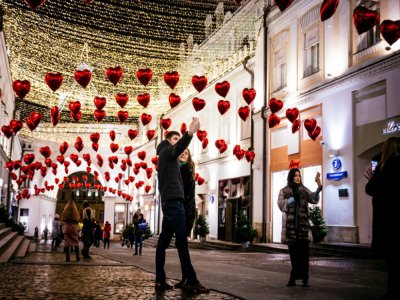 Des Moscovites dans une allée décorée de coeurs pour la Saint-Valentin, à Moscou le 13 février 2020 - Dimitar DILKOFF [AFP]
