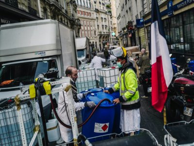 Des employés devant une fabrique improvisée de gel hydroalcoolique dans le VIe arrondissement de Paris, le 27 mars 2020 - LUCAS BARIOULET [AFP]