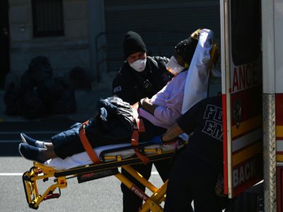 Des ambulanciers transportent un malade à l'hôpital de Brooklyn, le 27 mars 2020 à New York - Angela Weiss [AFP]